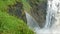 Water streams fall into the gorge. A rainbow formed between the stony slopes.