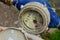 The water supply system manager checks the condition of the water meter. The display is full of water and dew under a glass cover.