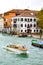 Water taxi and a boat transporting goods, sailing through the Grand Canal in Venice, Italy