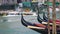 Water taxi carrying tourists in Venice, gondolas parked along canal, sightseeing