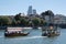 Water taxis with tourists sailing on the river Rhine in Basel. Roche towers in background