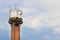 Water tower made of bricks, aluminum sheets, with metal pipes, glass small windows and a metal staircase