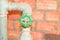 Water valve plumbing joint steel old tap pipe with green knob on brick background