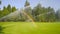 water waters the lawn on the golf course. a rainbow appeared on a sunny day