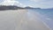 Water waves blue sea on sandy beach view from above. Sea waves splashing on sandy beach on tropical island on mountain