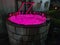 A water well lighted up with pink light