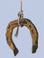 Watercolor hand drawing of old rusty horseshoe hanging on rope