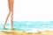 Watercolor landscape of sandy seashore of azure ocean with standing bare tanned female legs. Hand drawn brush stroke summer