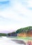 Watercolor peaceful landscape. Serenity of smooth lake surface and blurred silhouettes of forest beneath soft blue sky with fluffy