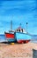 Watercolor picture of two colorful fishing boats on a sandy seashore