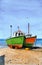 Watercolor picture of two colorful fishing boats on a sandy seashore