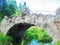 Watercolor style and abstract illustration of river, old stone bridge and forest