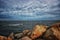 Watercraft person riding a boat on cloudy summer day rocks