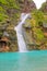 Waterfall in Ayn Khor and Lush green landscape, trees and foggy mountains at tourist resort, Salalah, Oman