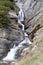 Waterfall below the summit of a mountain road Stelvio, Italy