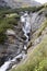 Waterfall below the summit of a mountain road Stelvio, Italy