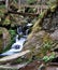 Waterfall on Bila Opava river with wooden bridge above