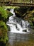 Waterfall on Bila Opava river with wooden bridge above