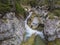 Waterfall cascade on wild river stream studeny potok with boulders, autumn colored tree at mountain valley Velka Studena