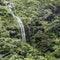 Waterfall cascading down a mountain in green surroundings