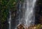 Waterfall cascading onto a rocky rubble at its cliff base