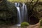 Waterfall Cascading through Tree Roots Tufa Dam, L