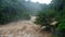 Waterfall cataract in forest mountains. Dirty streams are flowing down the mountain slopes of the mountain forest after heavy