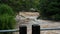 Waterfall cataract in forest mountains. Dirty streams are flowing down the mountain slopes of the mountain forest after heavy