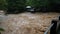 Waterfall cataract in forest mountains. Dirty streams are flowing down the mountain slopes of the mountain forest after heavy