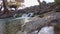 The waterfall with clear cold water among rocks and trees