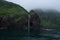 Waterfall dropping from high rocky cliffs into the ocean Sea of Okhotsk around the Shiretoko Peninsula