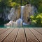 Waterfall and empty wooden deck table.