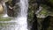 Waterfall ending in the water, mossy rocks in closeup with flowing water, nature background