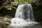 Waterfall flowing in a hidden place in a green peaceful place