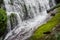 Waterfall flows down to earth with moss covered