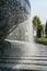 Waterfall flows in streams into granite bed of artificial river. Fountain in form of huge bowl. Public landscape city park Krasnod