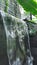 A waterfall in front of a stonewall with smooth but fast flowing water