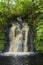 Waterfall with golden shimmering water, on the Isle of Skye