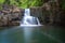 The waterfall in the hill behind a pond in jungle