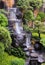 Waterfall in interior patio garden with river and lush vegetation in Yogyakarta, Java, Indonesia