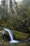 Waterfall Kamianka on a mountain river covered with moss in the forest in the sun