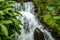 Waterfall landscape. Beautiful hidden Jembong waterfall in tropical rainforest in Ambengan, Bali. Fast shutter speed. Foreground