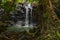 Waterfall landscape. Beautiful hidden waterfall in tropical rainforest. Nature background. Fast shutter speed. Sing Sing Angin