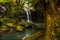 Waterfall landscape. Beautiful hidden waterfall in tropical rainforest. Tree with a swing. Fast shutter speed. Sing Sing Angin