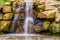 Waterfall with large boulders, Beautiful garden architecture, nature background of streaming water