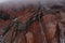 A waterfall of meltwater coming from a gletser from the chimborazo surrounded by rocks with a red grey and black coloration