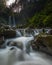 the waterfall is in the middle of a forest that is still shady and cool looks very beautiful