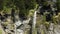 A waterfall in the middle of a green and rocky cliff