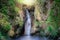 Waterfall on a mountain slope in deep forest. Tropical waterfall in rain forest.