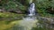 Waterfall in the mountains. River in the forest with cascading waterfalls. Gimbal slow motion shot